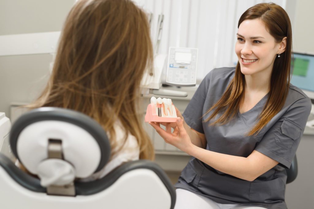 Doctor showing Dental Implant model to patient